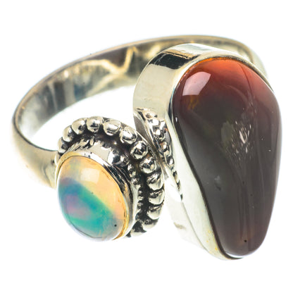 Sterling silver ring with dark red-brown oval cabochon, small blue-green opal bezel.