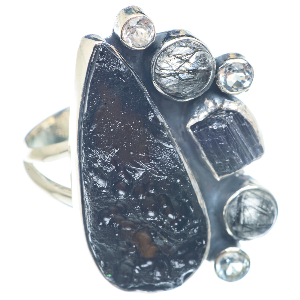 Sterling silver ring featuring large dark irregular center stone with bezel-set clear gems
