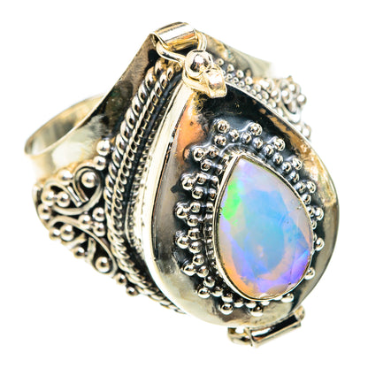 Large oval opal-like gemstone ring with ornate silver filigree and bezel setting