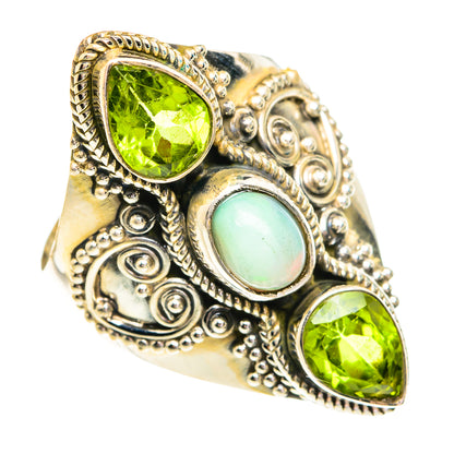 Ornate sterling silver ring with oval green peridot stones and light opal centerpiece