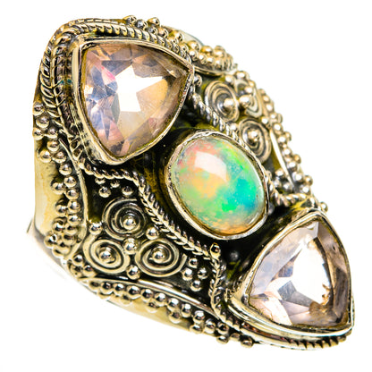 Ornate gold-tone ring with oval opal and two pear-shaped gemstones in filigree setting