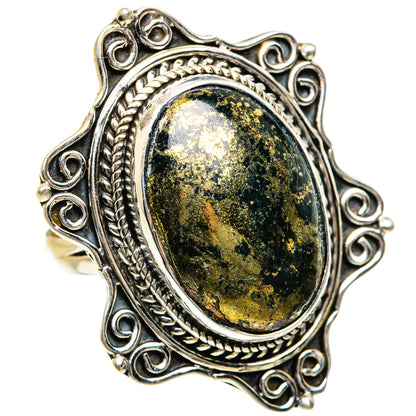 Silver ring with oval dark green-gold speckled gemstone in raised bezel with braided border