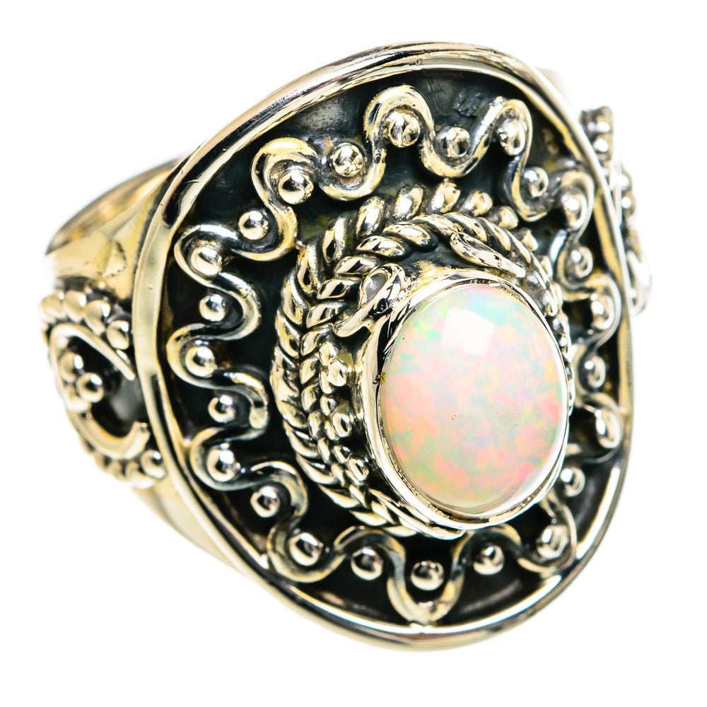 Oval opal cabochon in ornate silver ring with dark filigree bezel