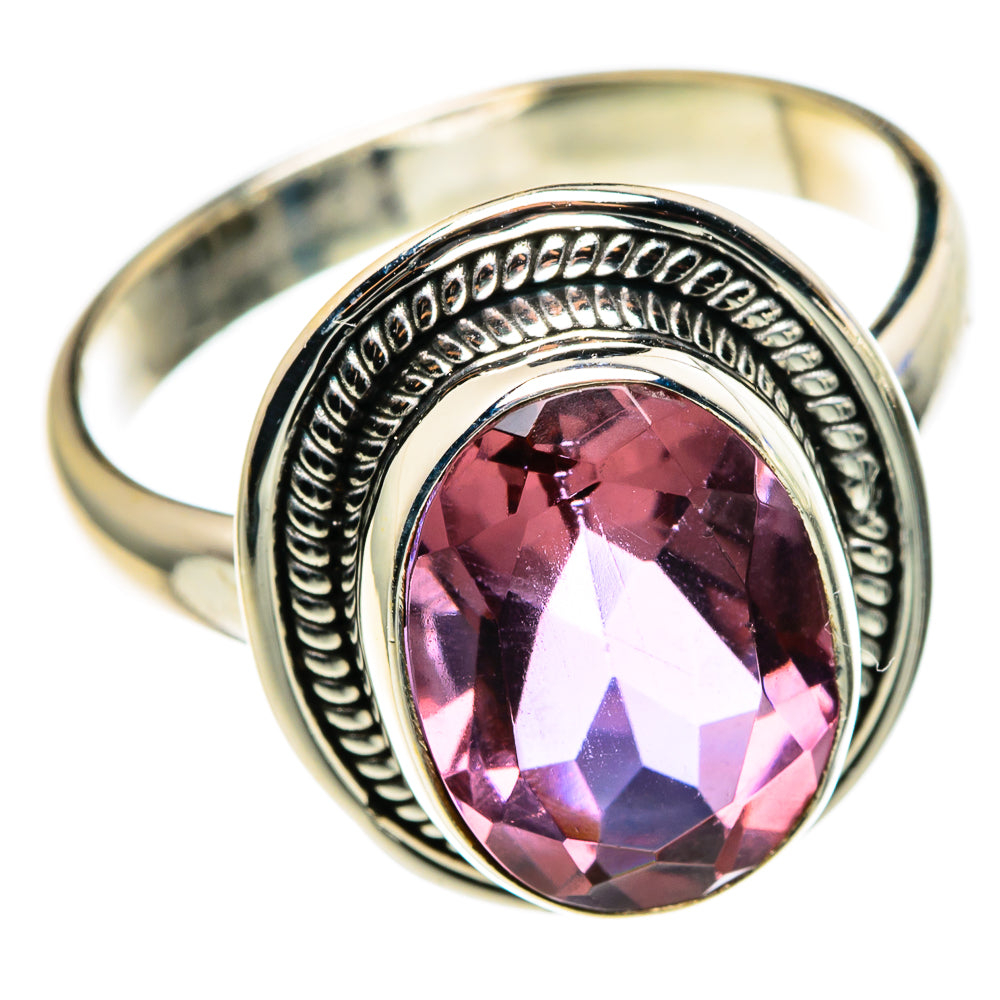 Gold-tone band ring with oval faceted pink gemstone and engraved silver halo