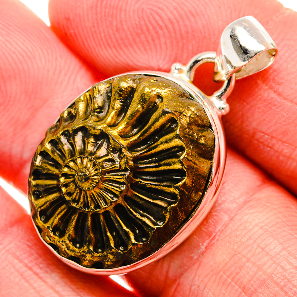 Pyrite fossil pendant close-up, round gold ammonite face in silver bezel with bail