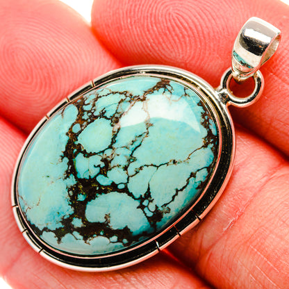 Oval sterling silver turquoise pendant with dark webbed stone and hinged bail