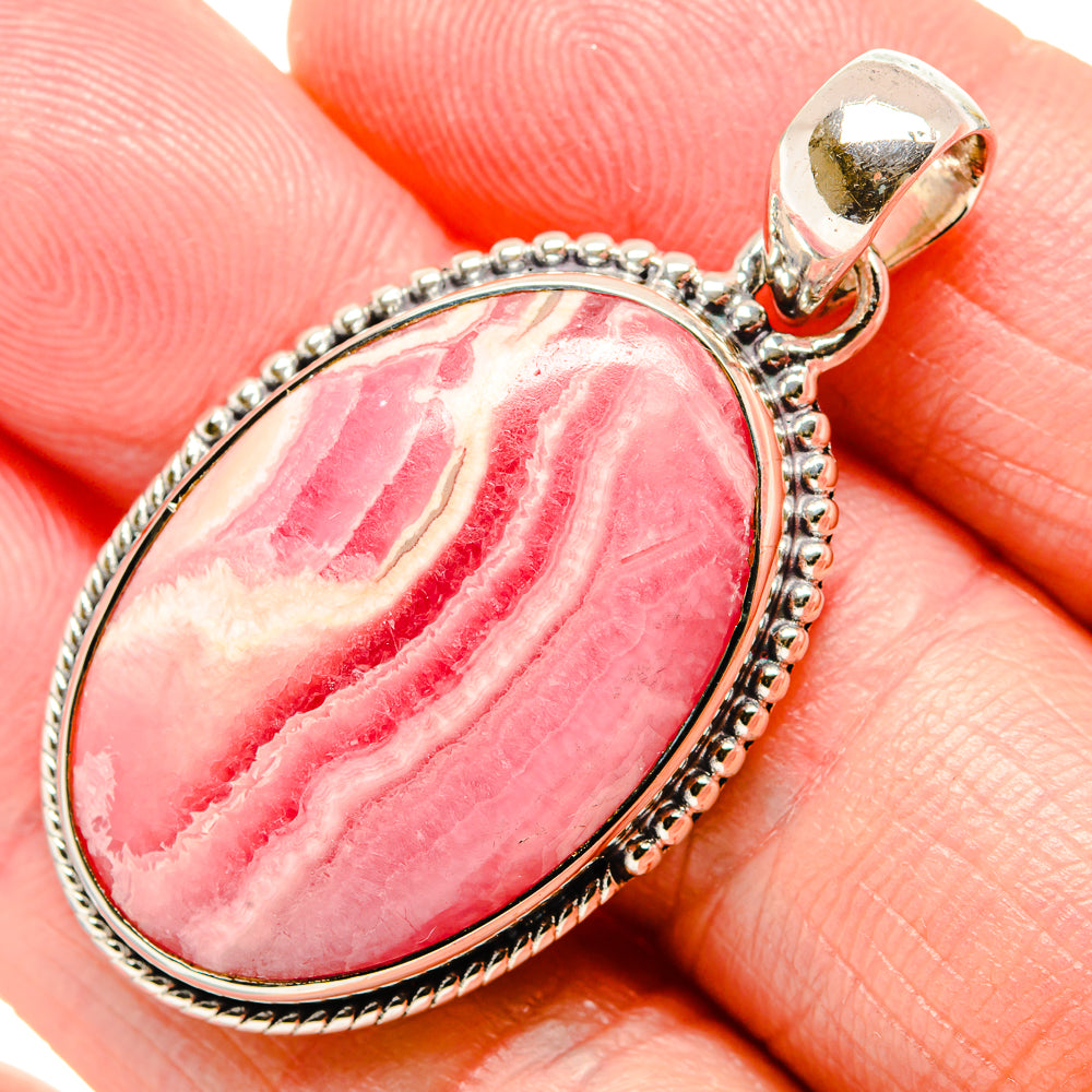 Oval rhodochrosite pendant in polished 925 sterling silver with textured bezel