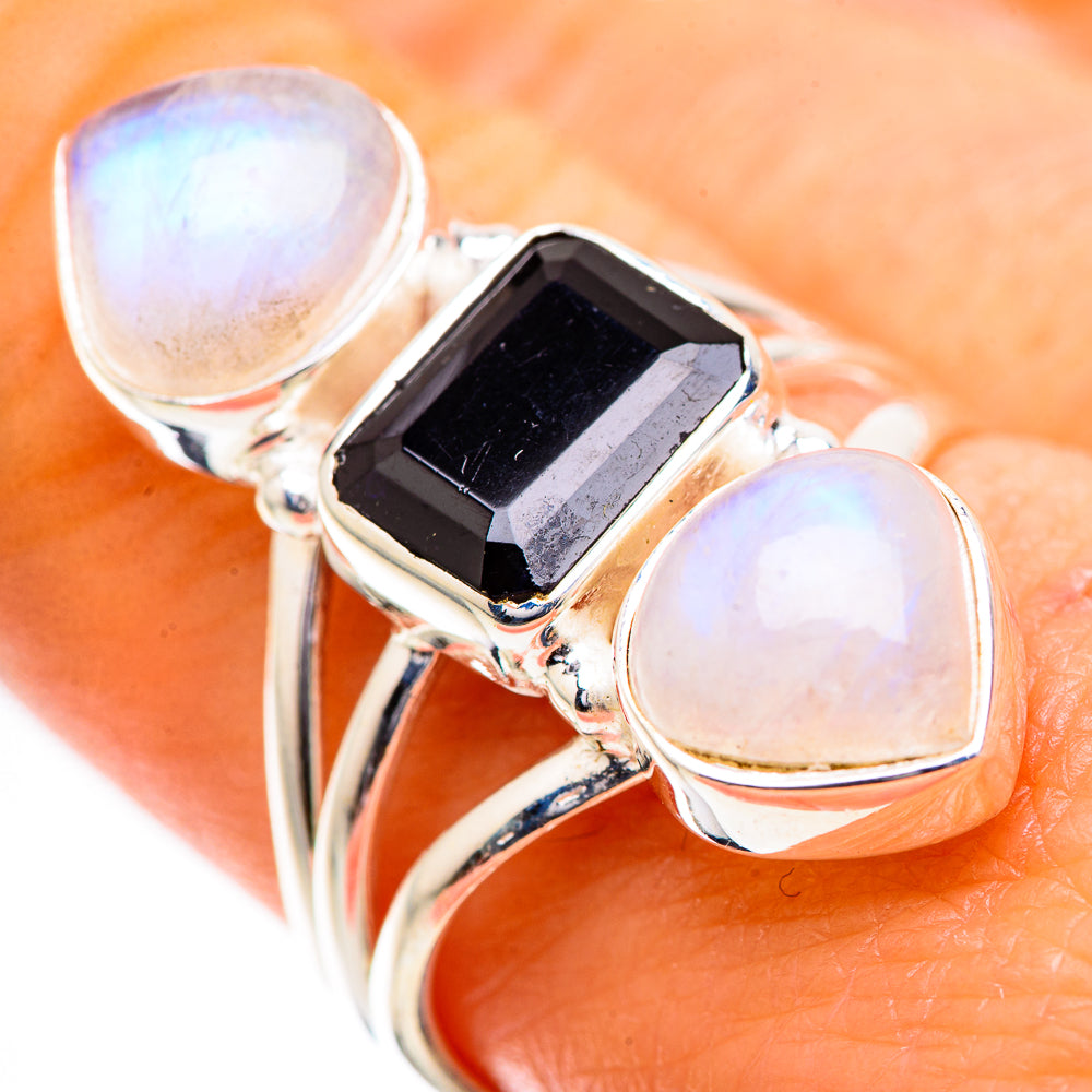 Sterling silver ring with dark faceted center stone and oval rainbow moonstone sides