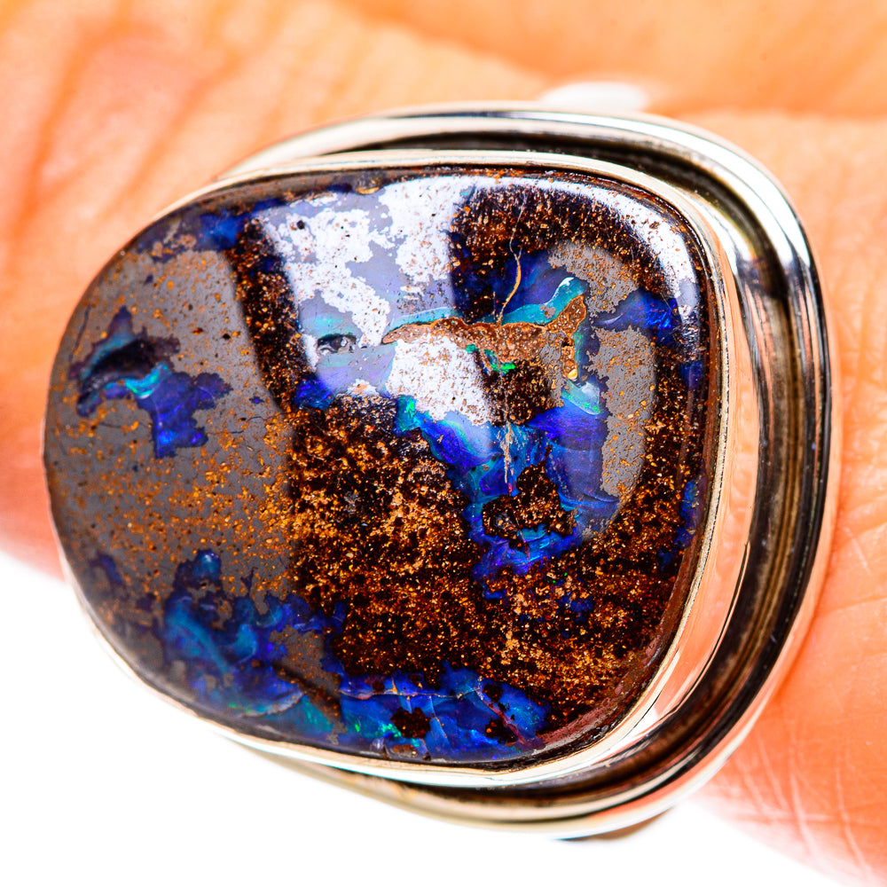 Oval boulder opal sterling silver ring with blue and teal stone in a metal bezel