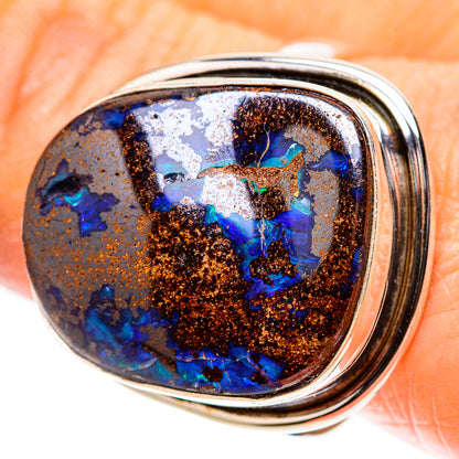 Oval boulder opal sterling silver ring with blue and teal stone in a metal bezel