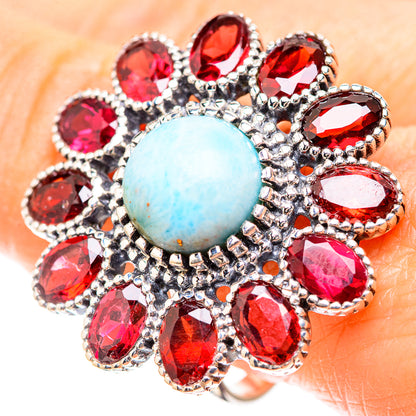 Sterling silver statement ring with oval light-blue center and red faceted gemstones