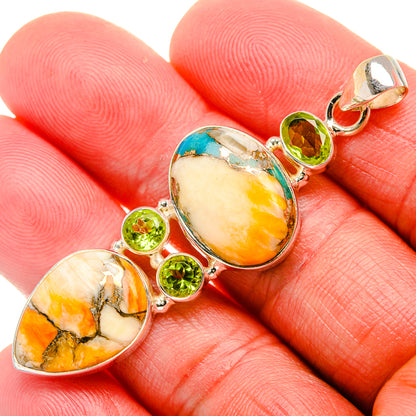 Oval spiny oyster and turquoise sterling silver pendant with green peridot accents.