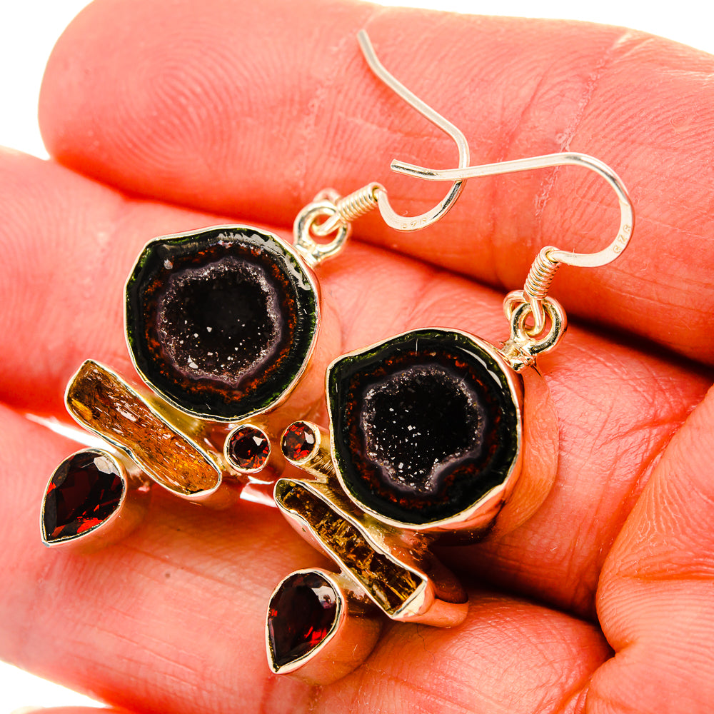 Gold-tone earrings with black druzy geode ovals, orange stones, and silver hook back